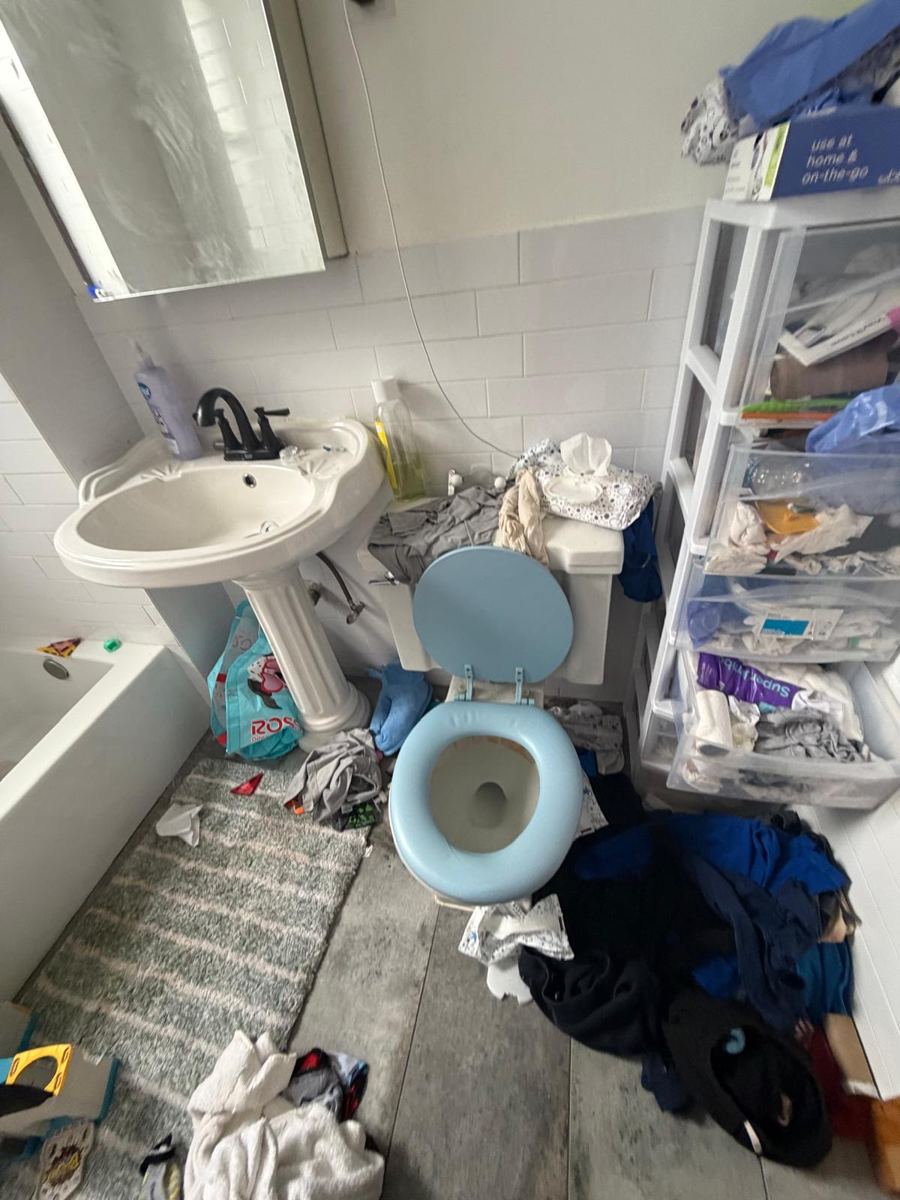 Bathroom floor buried in laundry