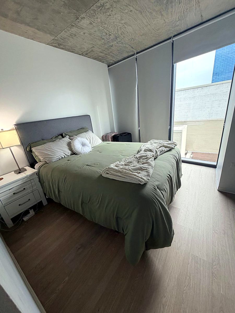 The same bedroom with the bed made and floor clear
