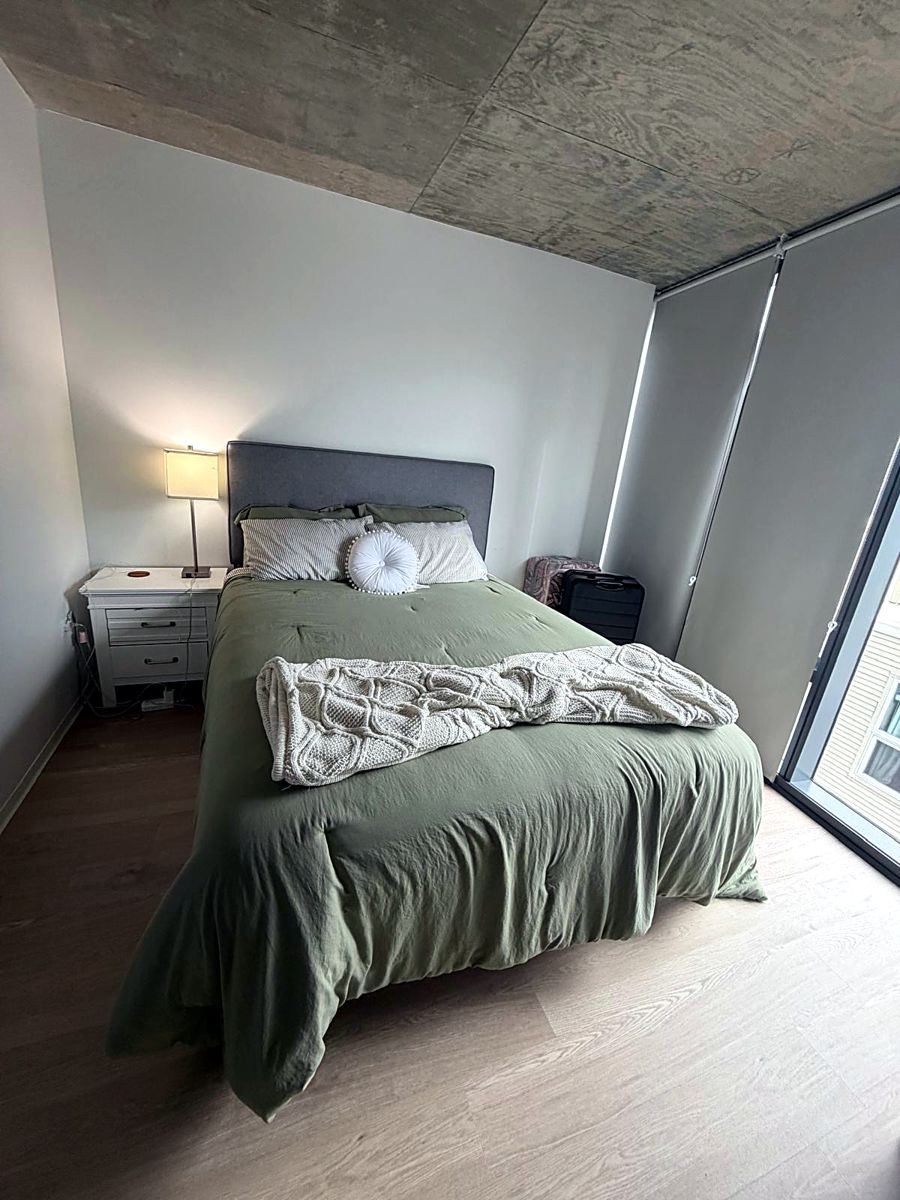 Bedroom with bed made and hardwood floors cleaned