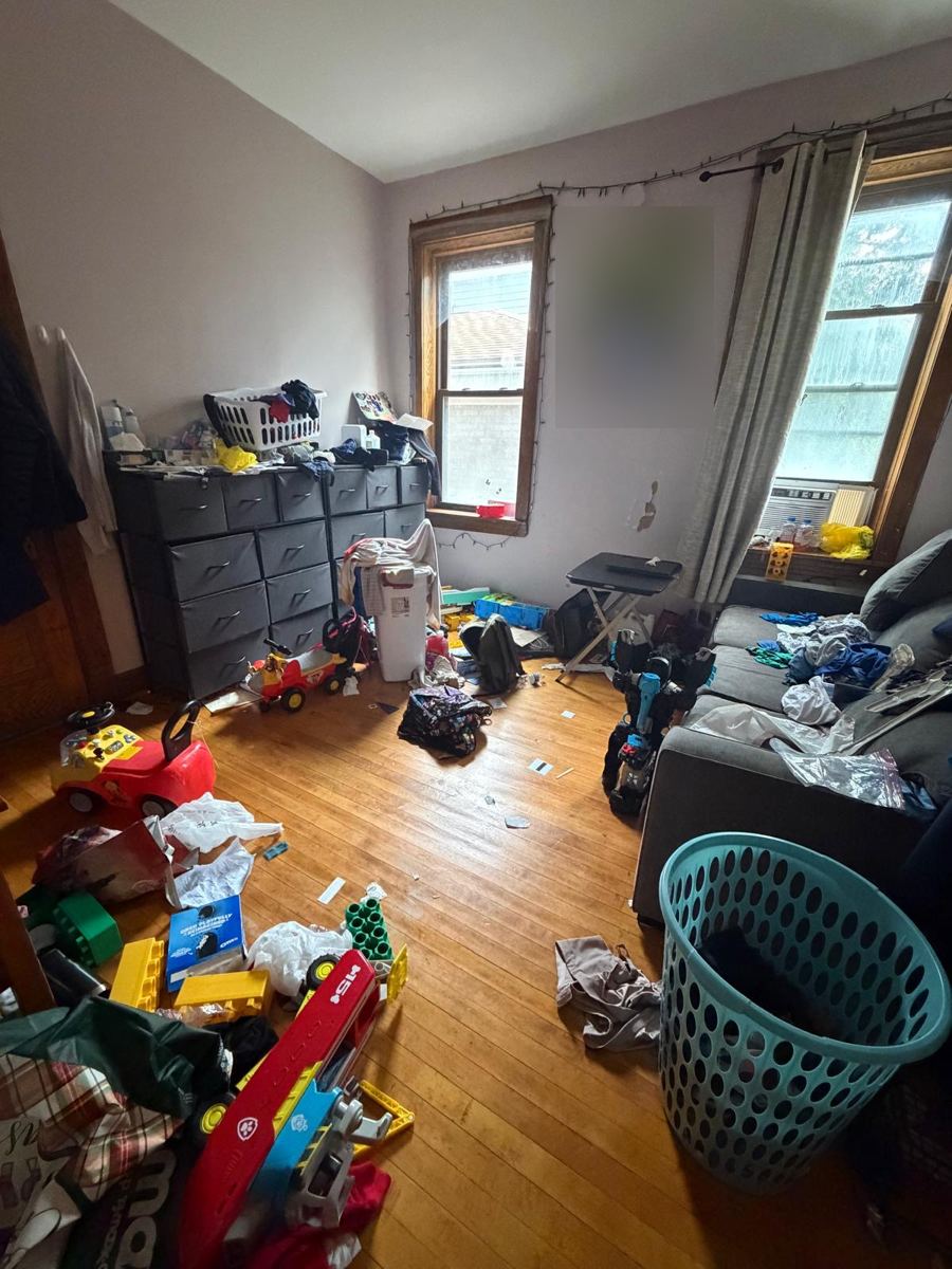 Living room floor covered in toys and clothes