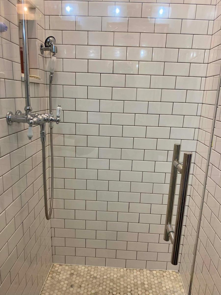 The same shower with clear glass and bright tile