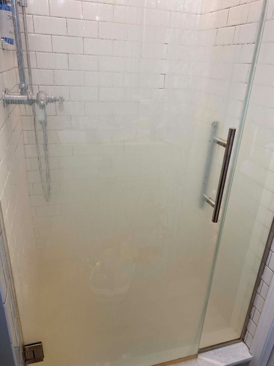 Glass shower door clouded with soap scum
