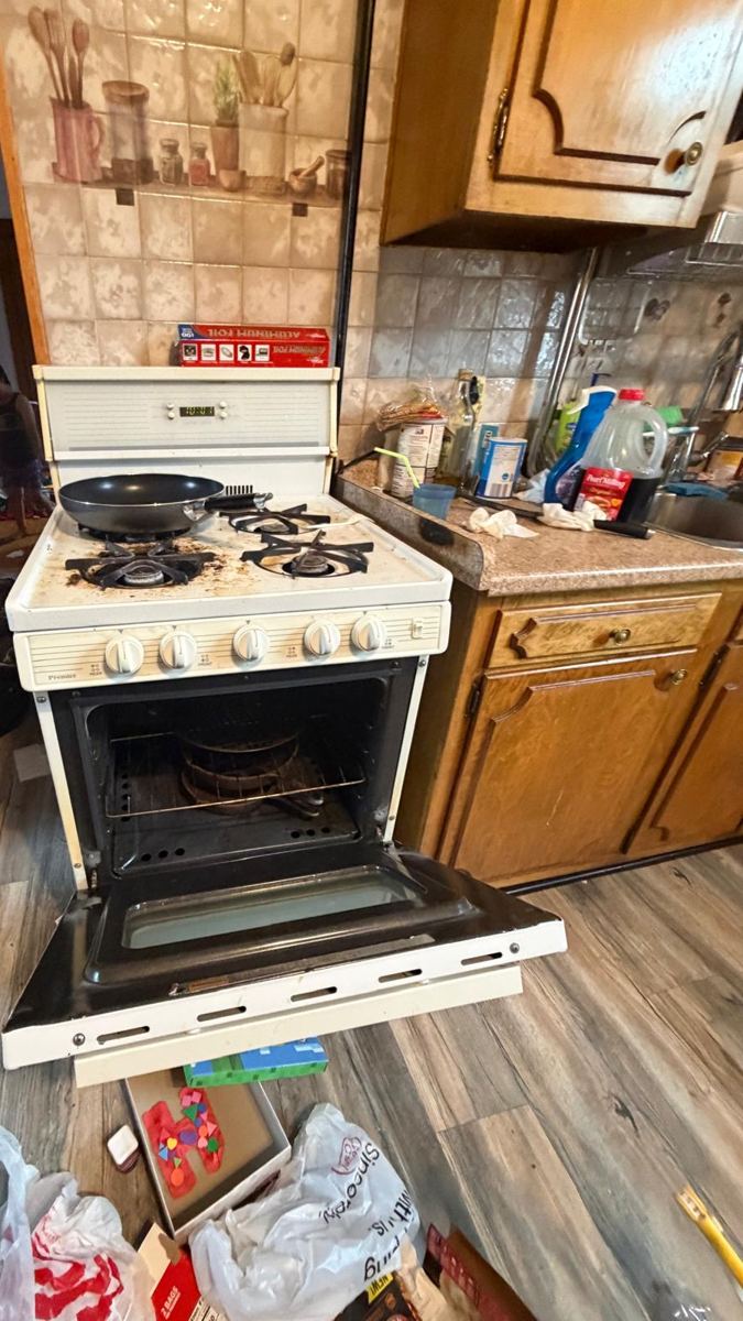 Cluttered kitchen with a dirty stovetop